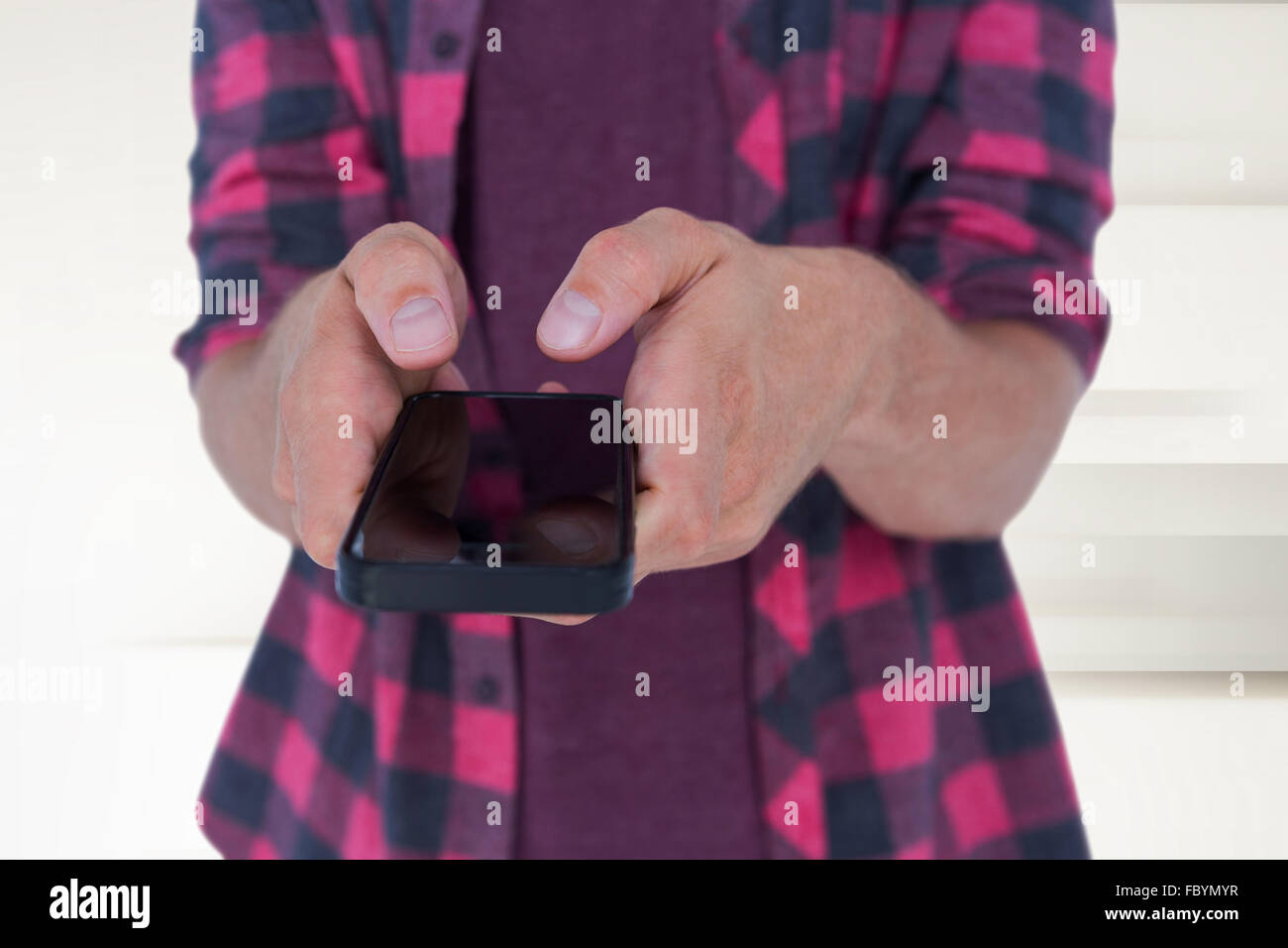 Immagine composita della sezione mediana dell'uomo in casuals utilizzando smart phone Foto Stock