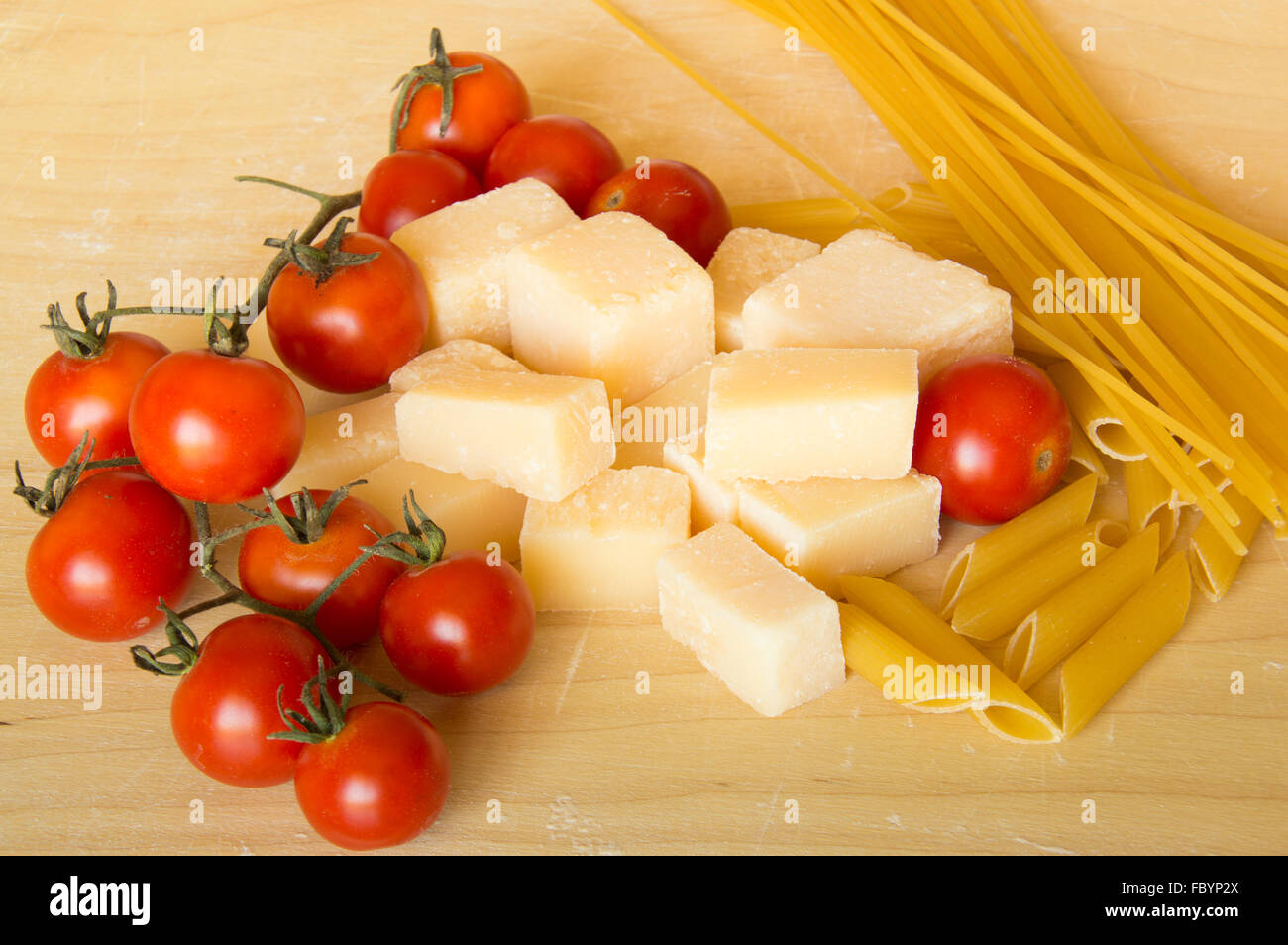 Il Grana Padano italiano, pasta e pomodori su uno sfondo di legno Foto Stock