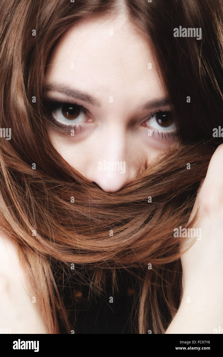 La donna ricopre la faccia da lunghi peli di colore marrone Foto Stock