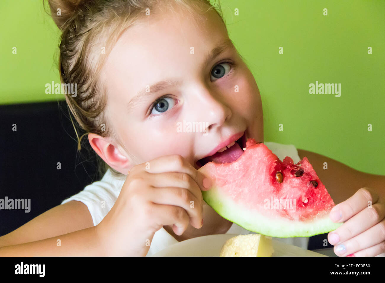 Ragazza carina mangiando anguria e melone Foto Stock