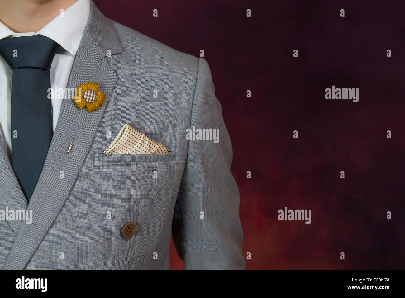 Uomo in abito grigio, plaid texture, cravatta blu, fiore spilla, e la configurazione di punti fazzoletto, close up Foto Stock