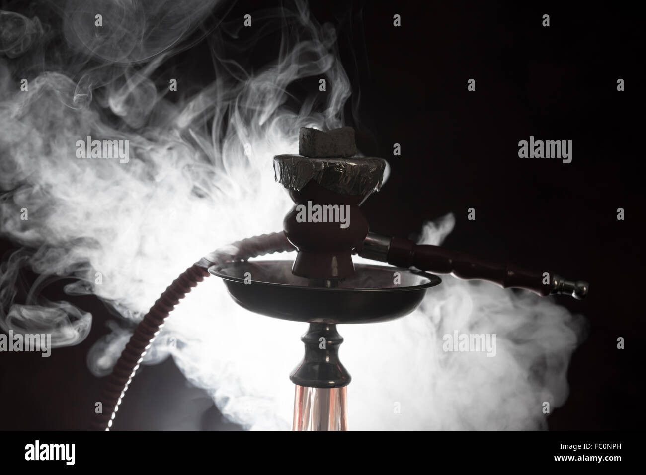 Ancora la vita di fumare shisha con fumo come sfondo Foto Stock