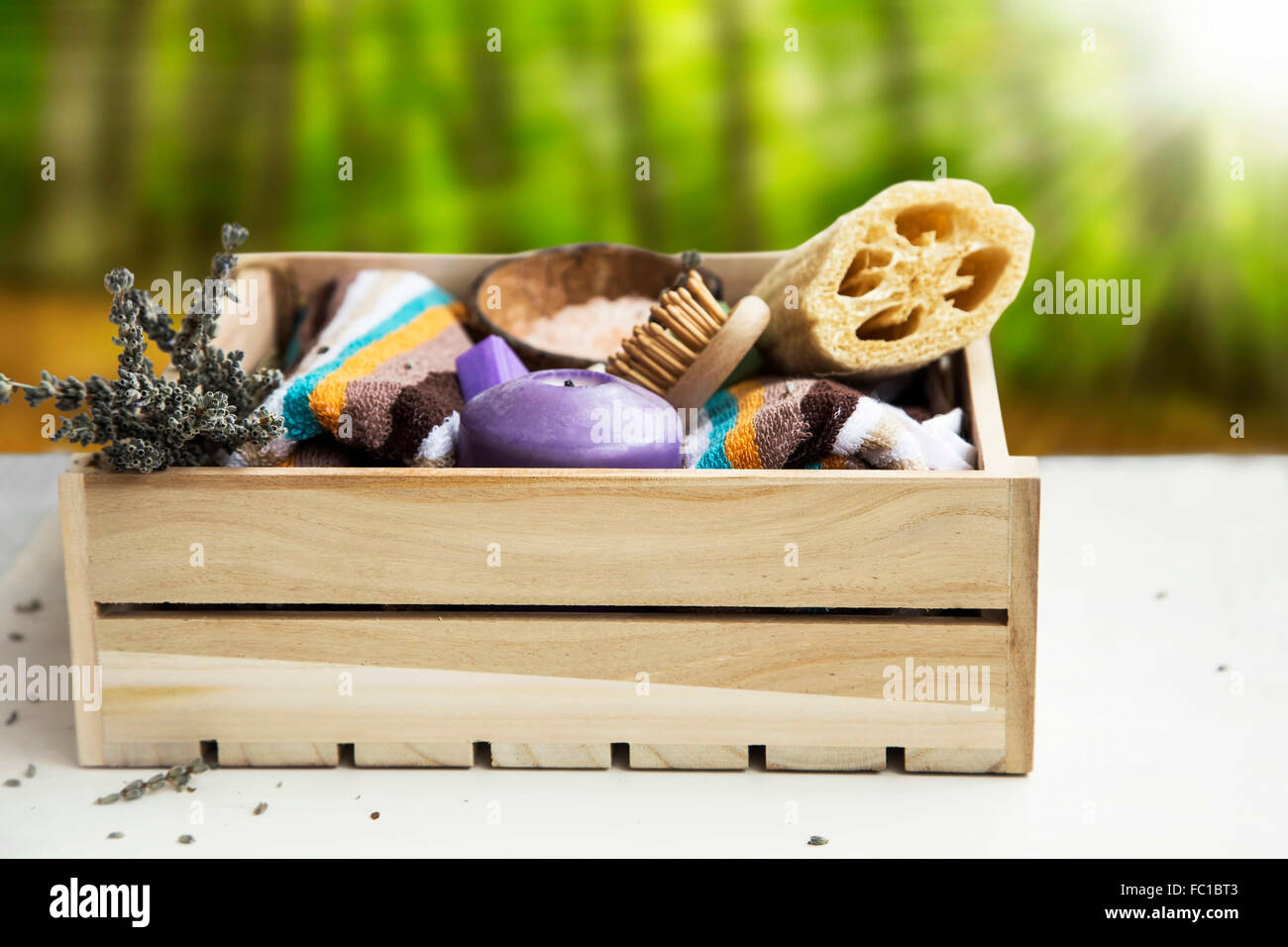 Prodotti per il benessere con asciugamani,loofah,bagno,sale lavanda essiccata,candela e saponi in cassetta di legno Foto Stock