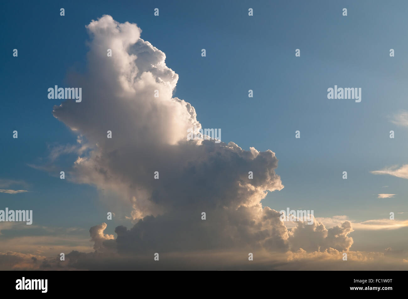 Enorme nube cluster bagnarsi in luce del tramonto che riflette sia il bianco e il colore arancione nello stesso cluster. Foto Stock