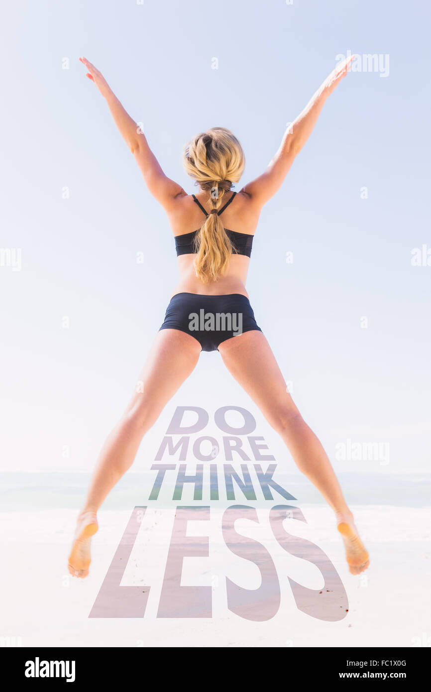 Immagine composita di montare blonde jumping sulla spiaggia con le braccia aperte Foto Stock