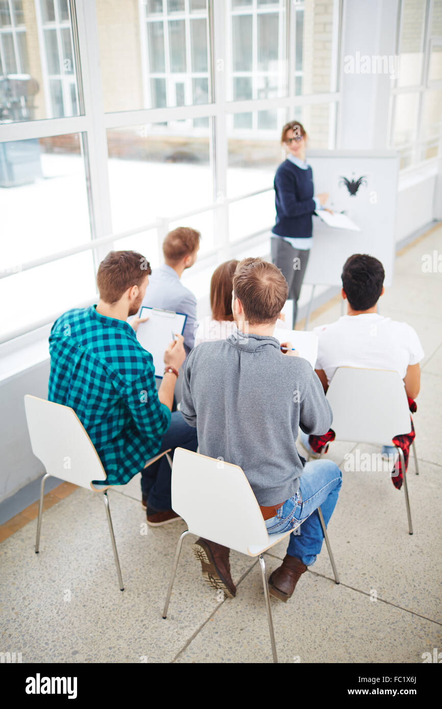 Persone creare delle note durante la lezione sulla psicologia Foto Stock