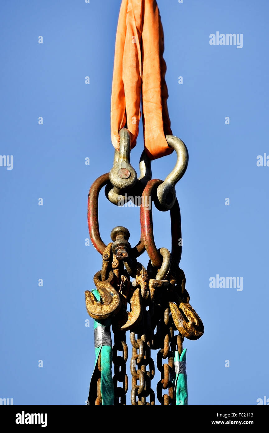 Per impieghi pesanti catene industriali e ganci isolati contro il cielo blu Foto Stock