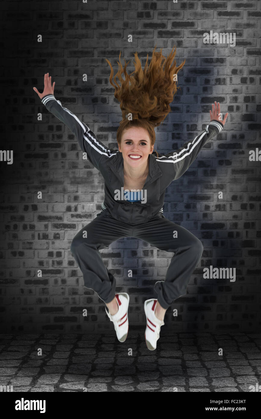 Immagine composita di lunghezza completa di una sportiva giovane biondo jumping Foto Stock