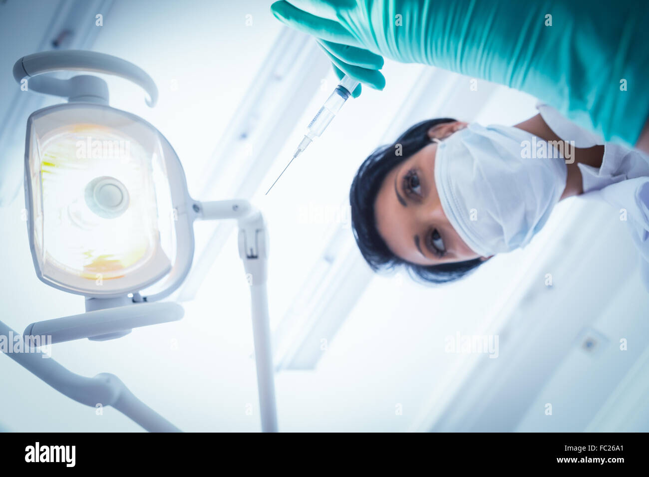 Dentista femmina nella mascherina chirurgica iniezione di contenimento Foto Stock