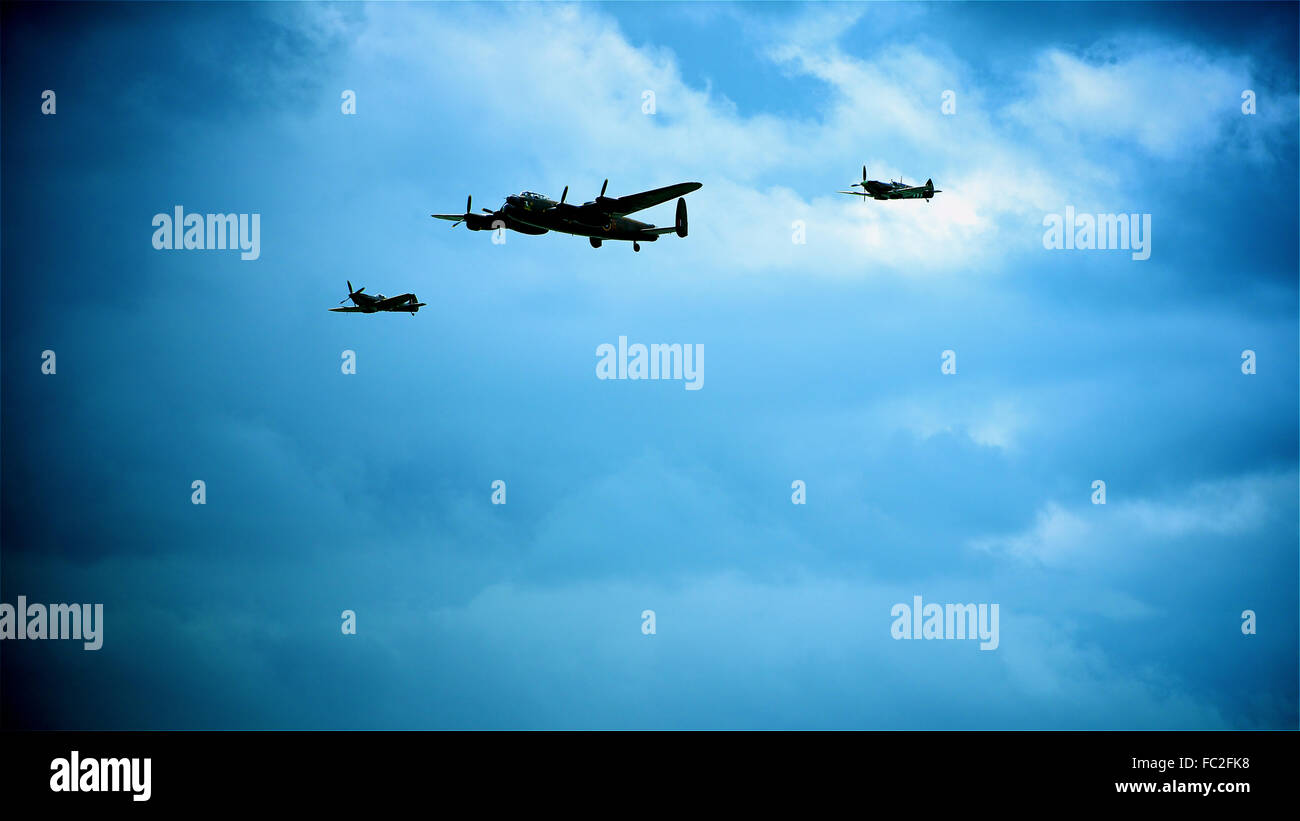 Bombardiere Lancaster con Hurricane e Spitfire escort contro un blu scuro cielo nuvoloso shot guardare come la notte, la luna luce atmosferica editoriale di immagine Foto Stock