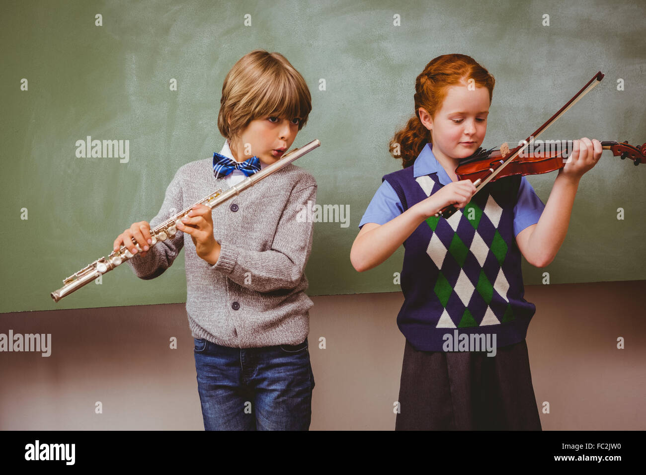 Gli studenti la riproduzione di flauto e violino in aula Foto Stock