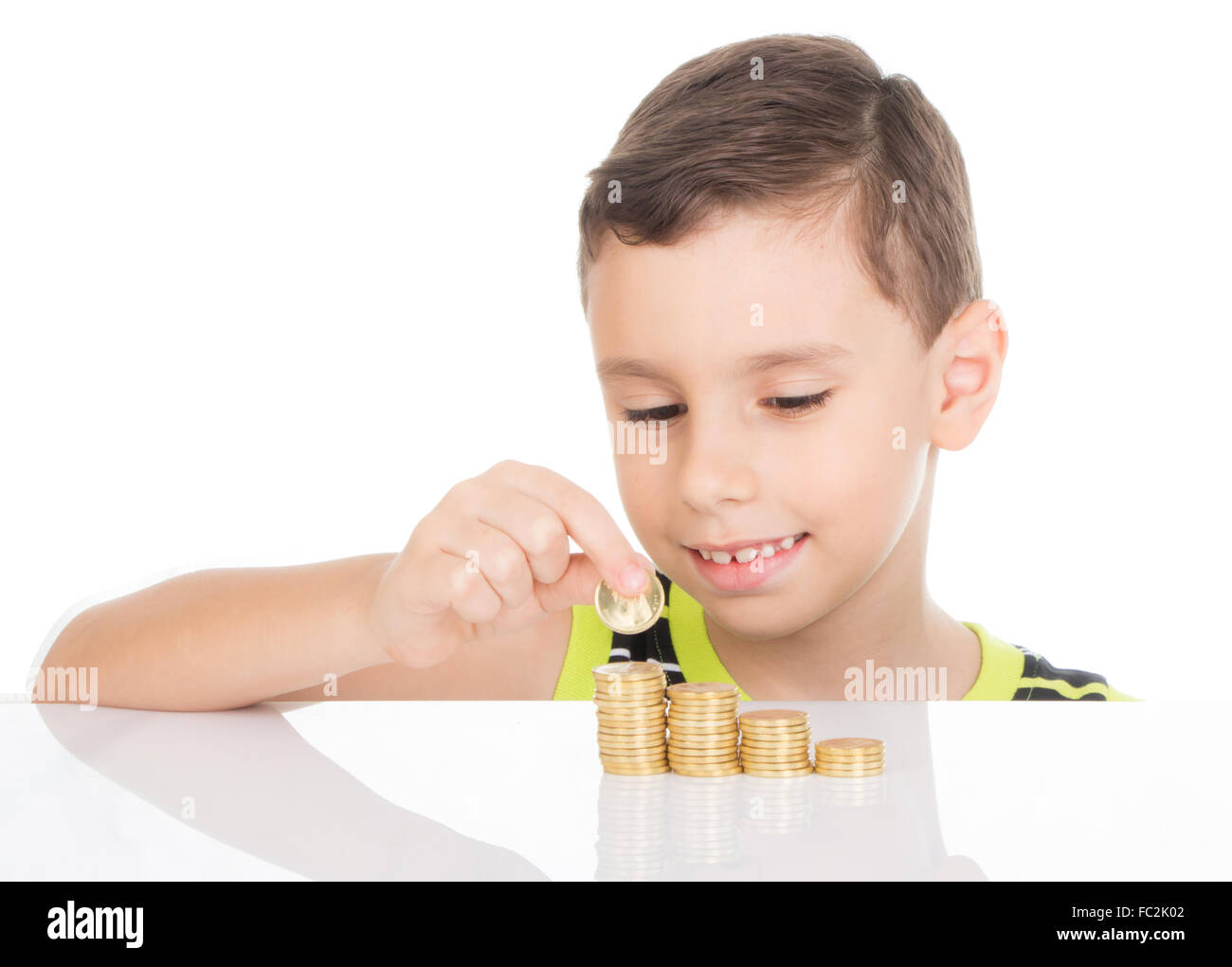 Bambino felice il suo conteggio delle monete d'oro Foto Stock