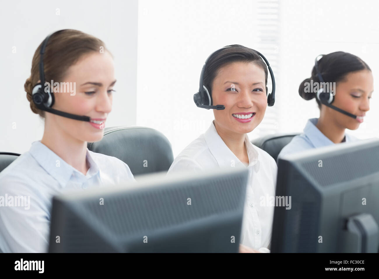 La gente di affari con cuffie sorridente in telecamera Foto Stock