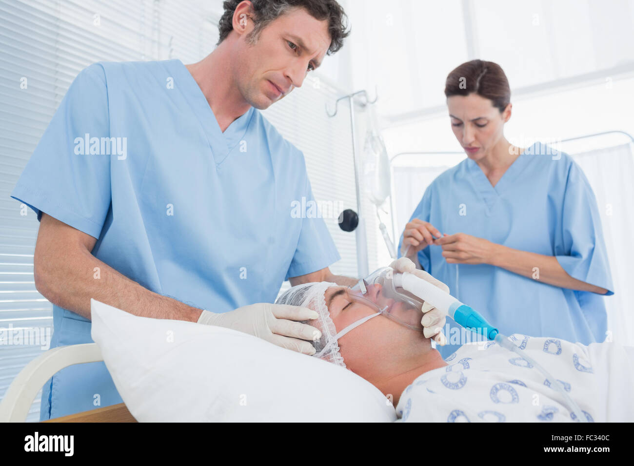 I medici tenendo le maschere di ossigeno e di esame di gocciolamento endovenoso Foto Stock