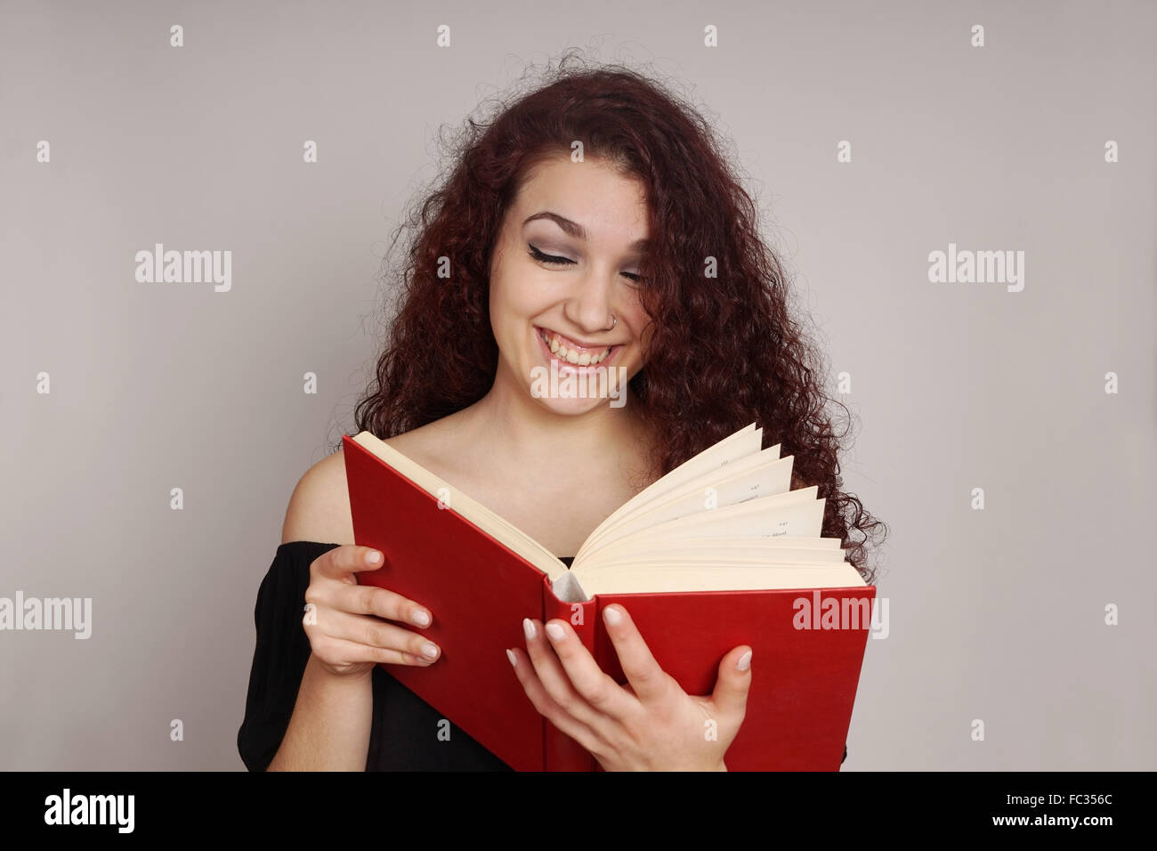 Lettura della ragazza di un divertente libro Foto Stock