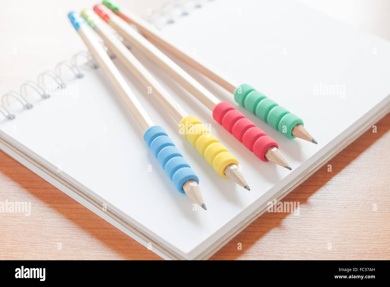 Matite sul fustellato aperto notebook bianco sulla scrivania, stock photo Foto Stock