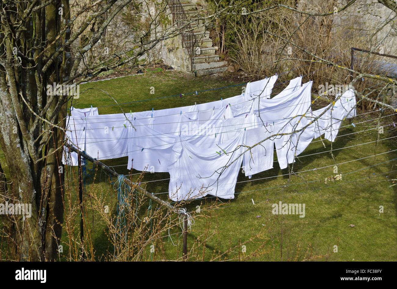Biancheria da letto bianca essiccazione su clotheslines Foto Stock