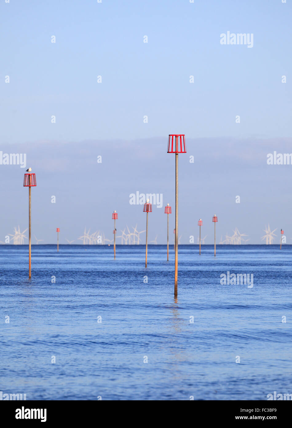 Marcatori per pennelli sommersi e delle turbine a vento in una calma il mare blu. Foto Stock