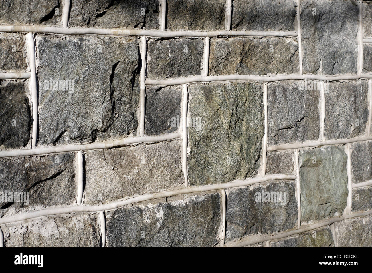 Panoramica della superficie ruvida tagliare granito muro di pietra con calce bianca Foto Stock