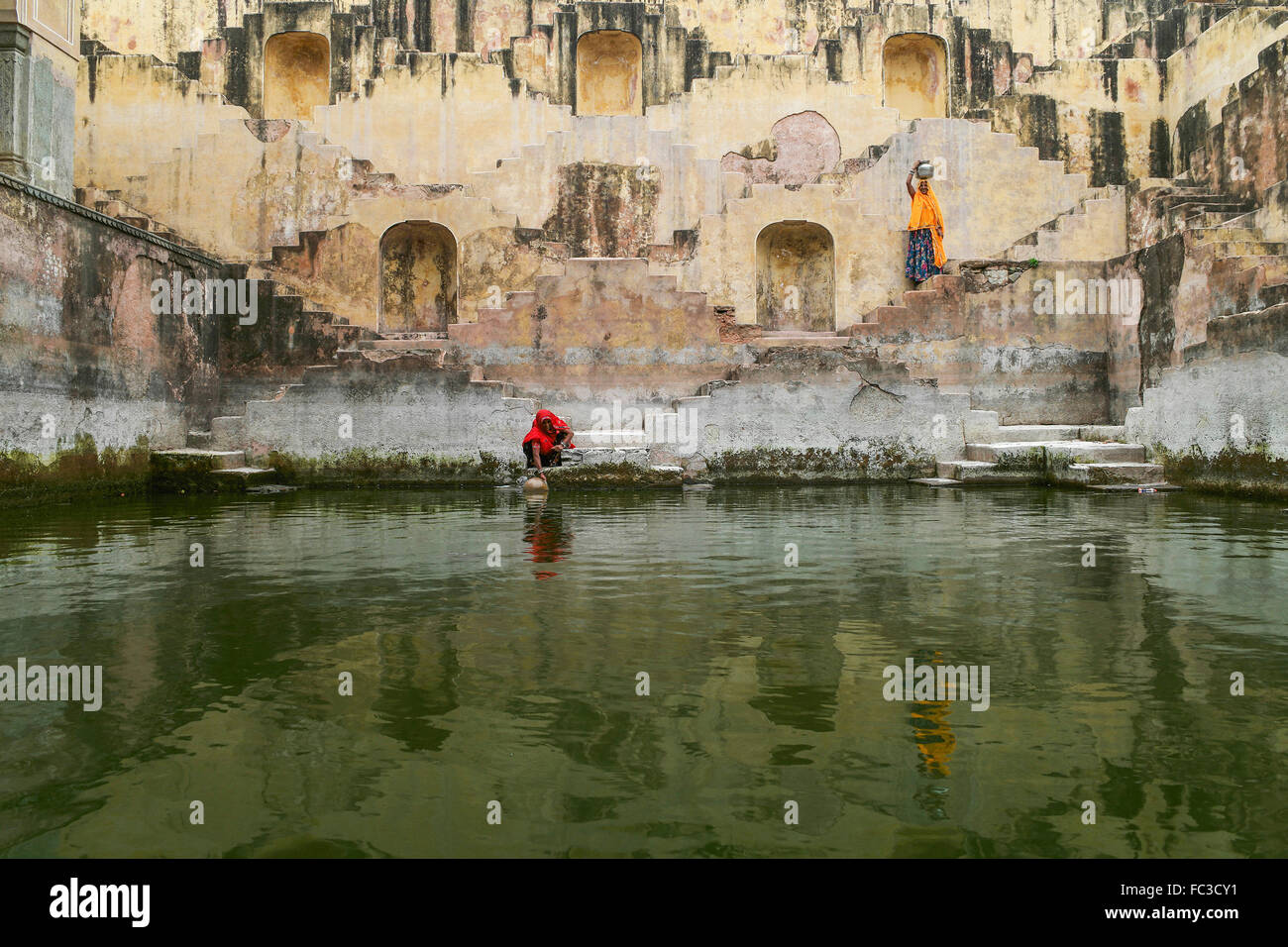 Due donne locali nel pozzetto gradini Nei punti di Chand Baori o panna Meena Ka Kund, a Jaipur, India. Foto Stock