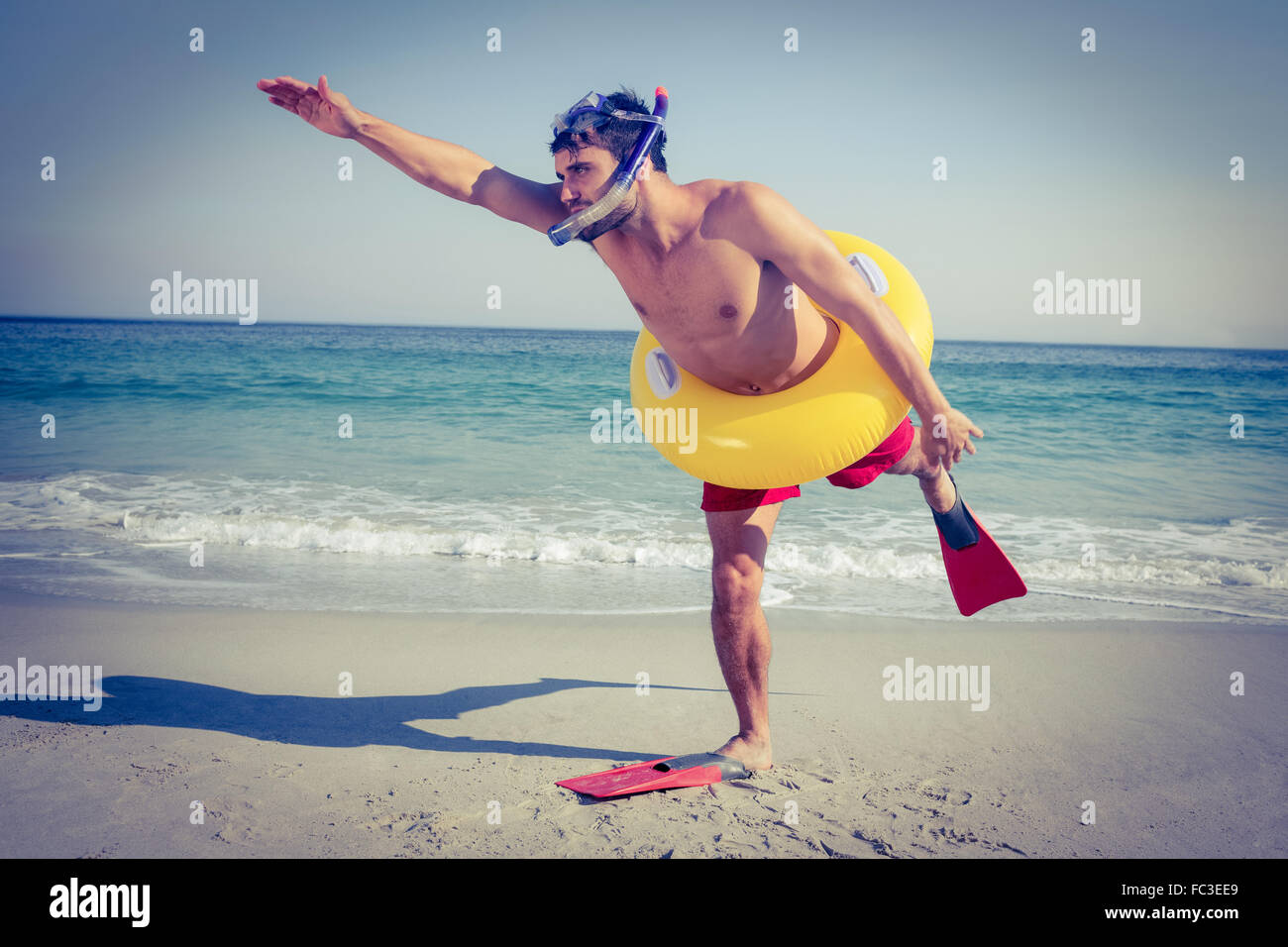 L'uomo indossare pinne e anello in gomma in spiaggia Foto Stock