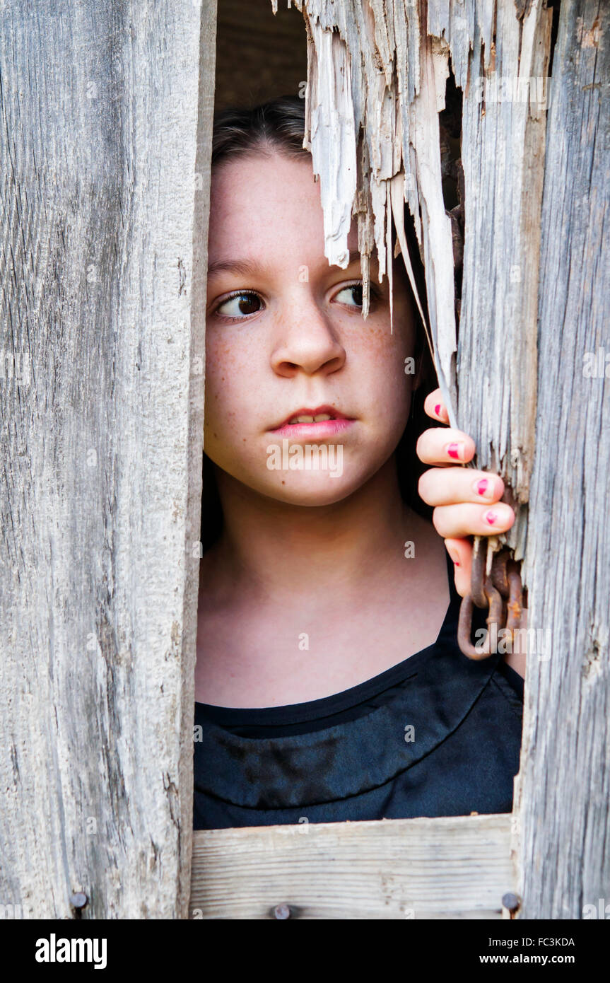 Ragazza che guarda fuori del granaio Foto Stock