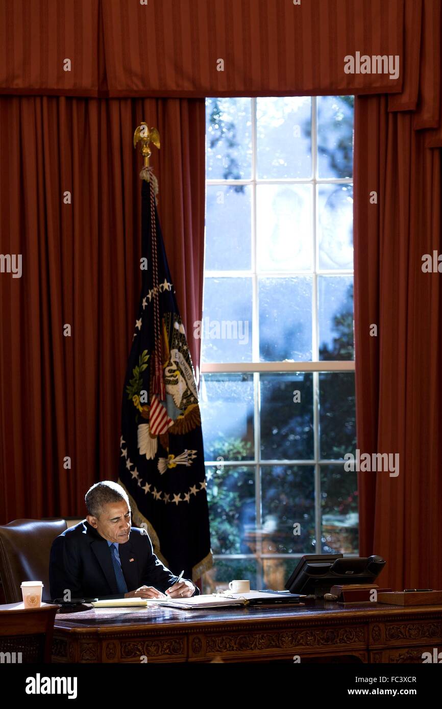 Il Presidente degli Stati Uniti Barack Obama lavora presso il banco risoluto come pomeriggio di flussi di luce attraverso la finestra nell'Ufficio Ovale della Casa Bianca Ottobre 23, 2015 a Washington, DC. Foto Stock