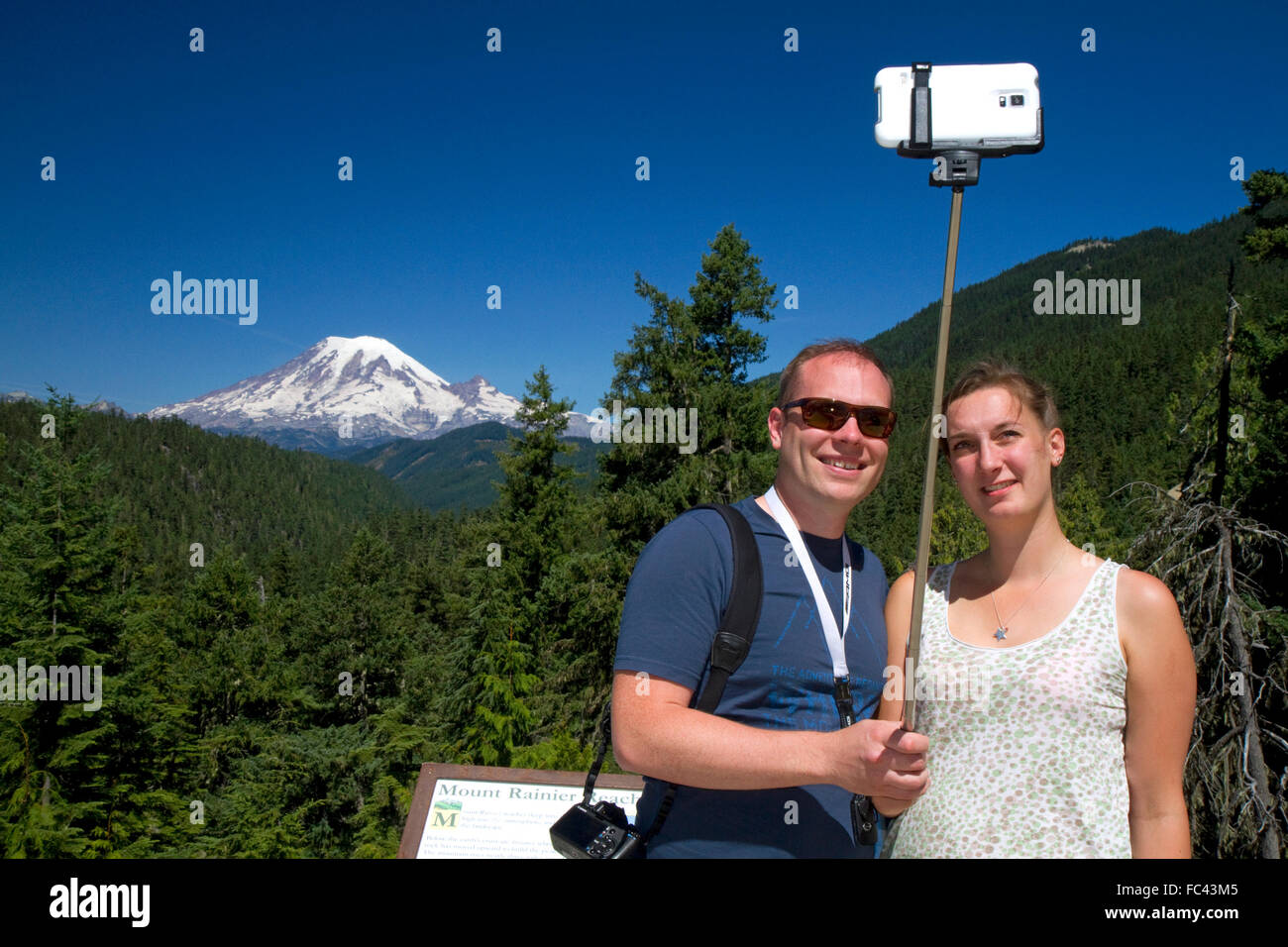 Turisti usano un selfie stick per prendere un selfie con uno smart phone a monte Rainier nello stato di Washington, USA. Foto Stock