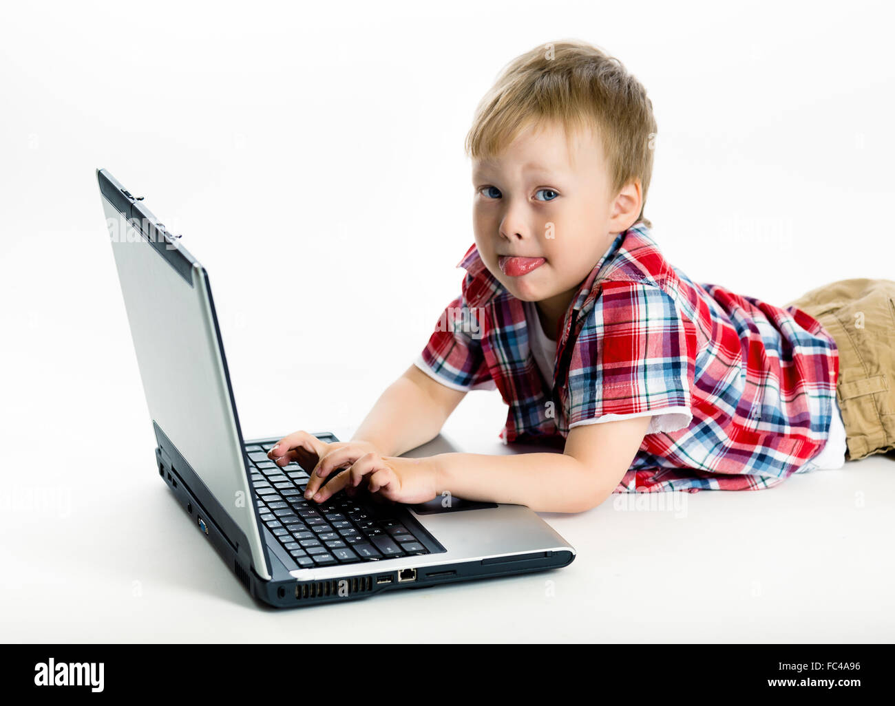 Ragazzo disteso sul pavimento con un computer portatile Foto Stock