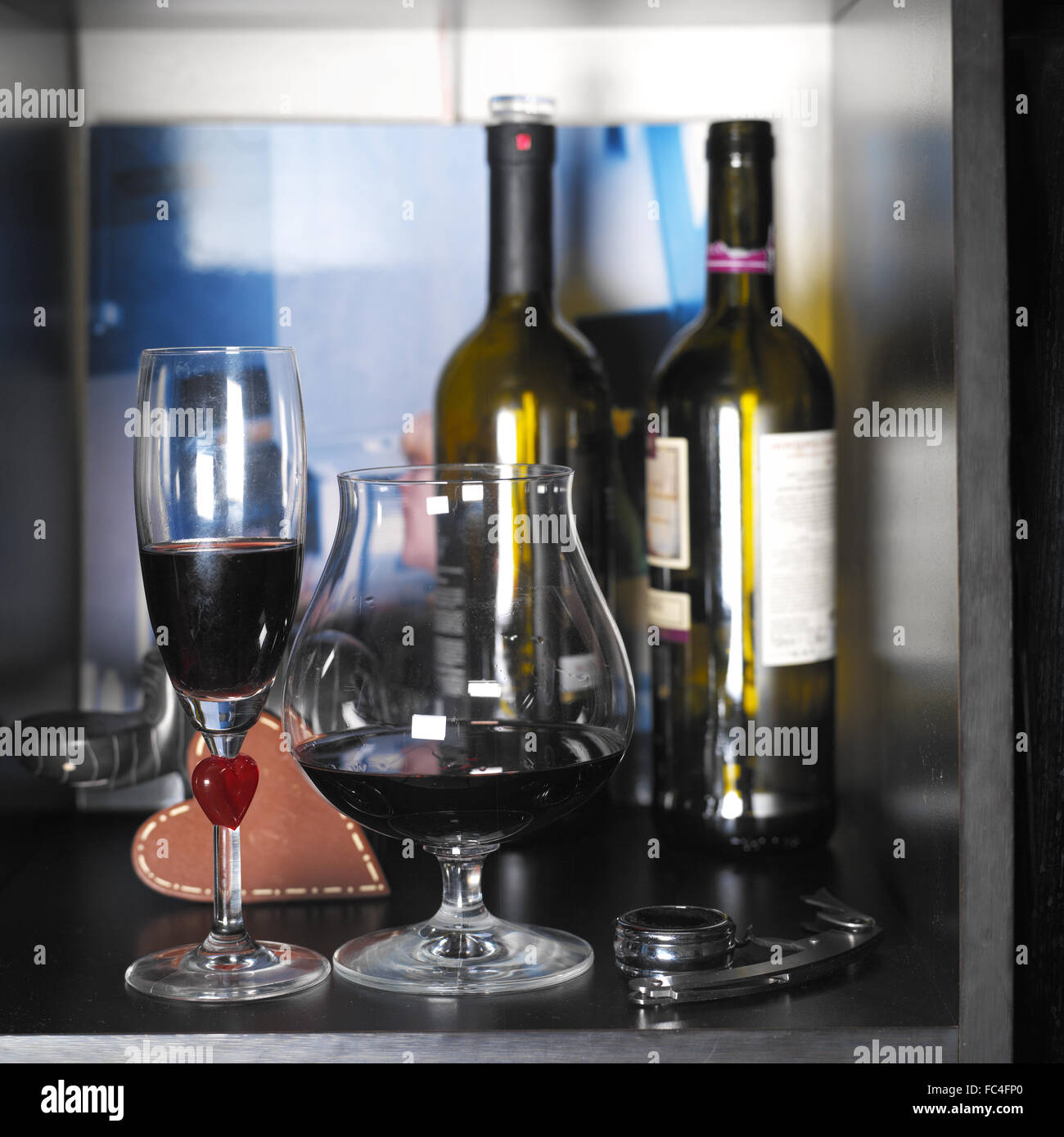 Due bicchieri di vino con un bicchiere di vino rosso accanto alla vite di sughero, piazza interna shot Foto Stock