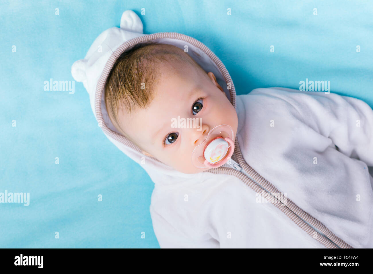 Baby nella cappa su una coperta di blu Foto Stock