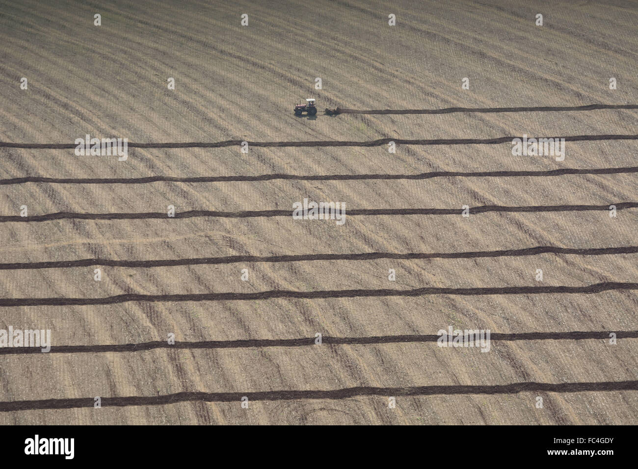 Vista aerea di macchine agricole prepara il terreno per la semina del mais Foto Stock