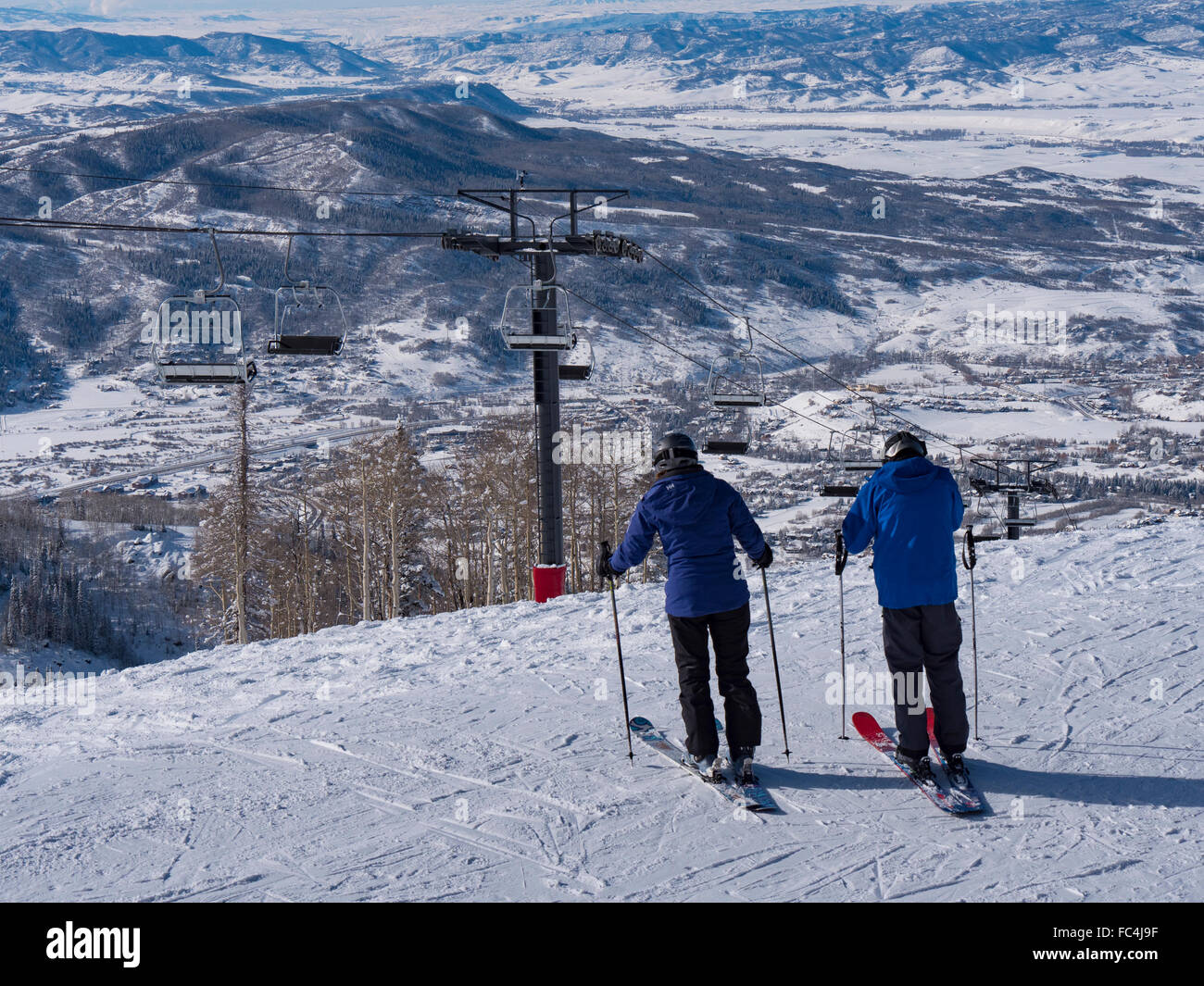 Gli sciatori iniziano la loro discesa da dietro i quattro punti Lodge, Steamboat Ski Resort, Steamboat Springs, Colorado. Foto Stock
