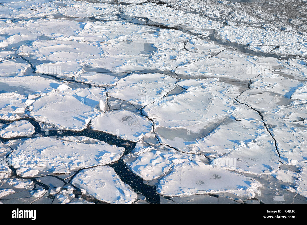 Rotto il ghiaccio sul fiume, inter sfondo ghiacciato Foto Stock