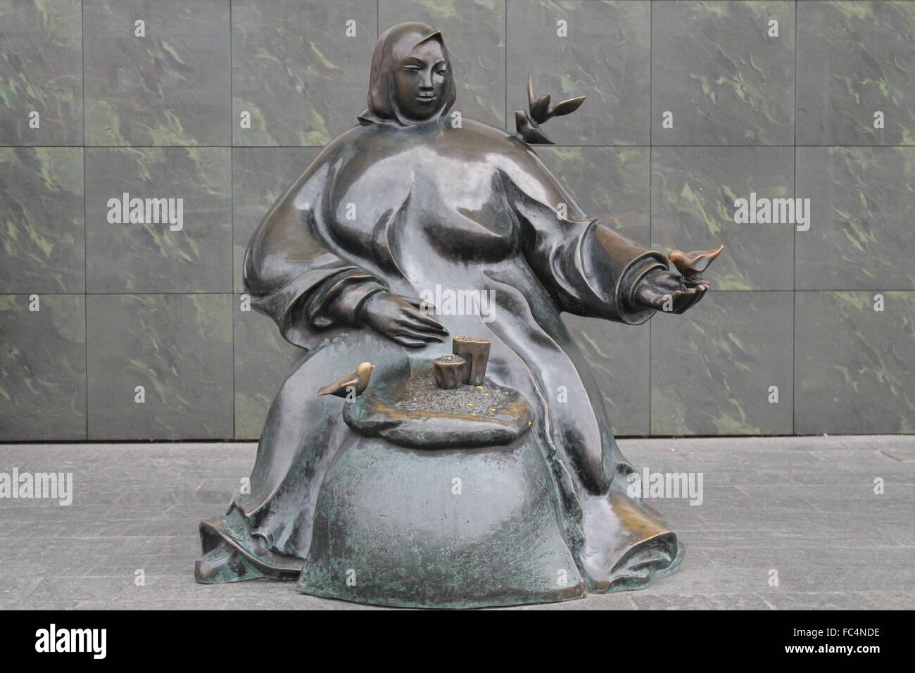 Statua di bronzo di grasso donna commercio sit e uccelli di alimentazione da mani,Septemer, 2015, Minsk Foto Stock