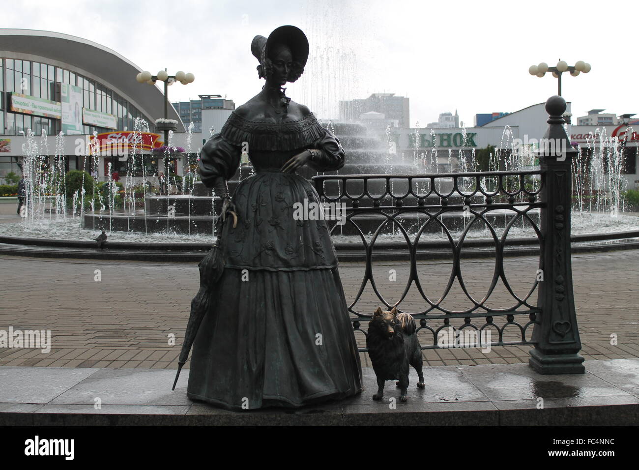 Statua di bronzo di giovane donna in stile retrò con piccolo cane rimanere sulla strada di città, settembre 2015, Minsk Foto Stock