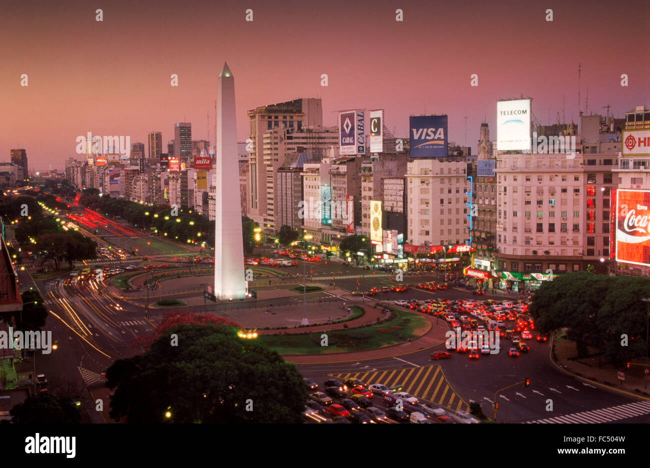 Avenida 9 de Julio al crepuscolo in Buenos Aires con obelisco e traffico Foto Stock