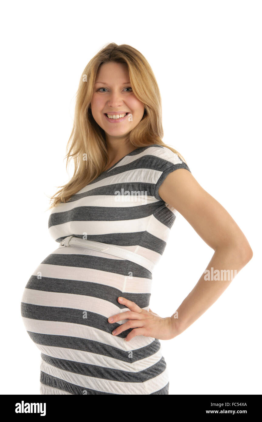 Felice donna incinta in abito a strisce Foto Stock