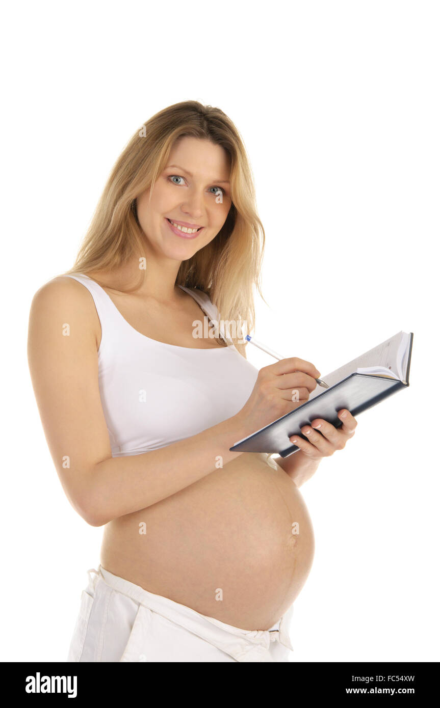 Felice la donna incinta ha scritto in un notebook Foto Stock