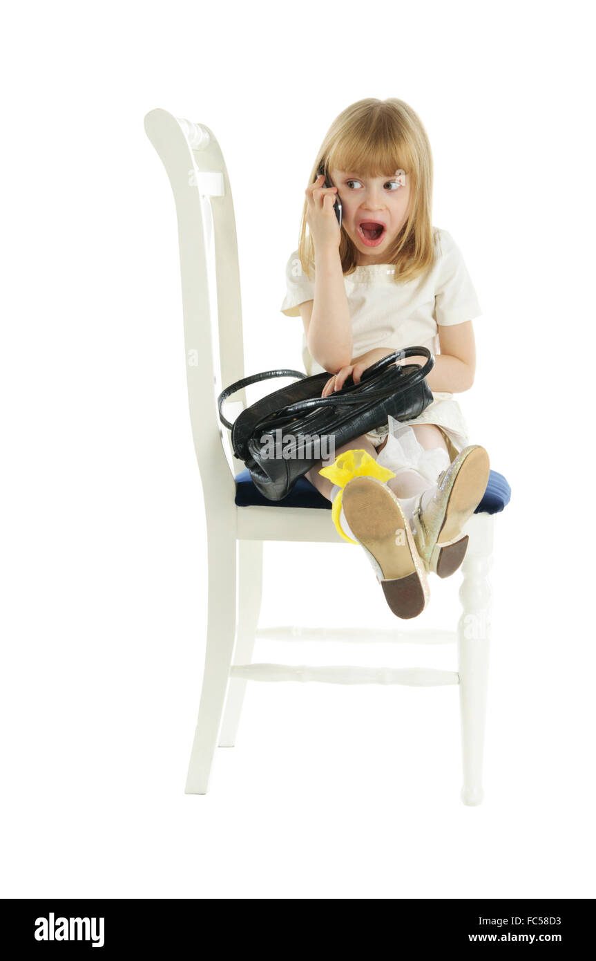 Sorpreso ragazza con telefono sulla sedia Foto Stock