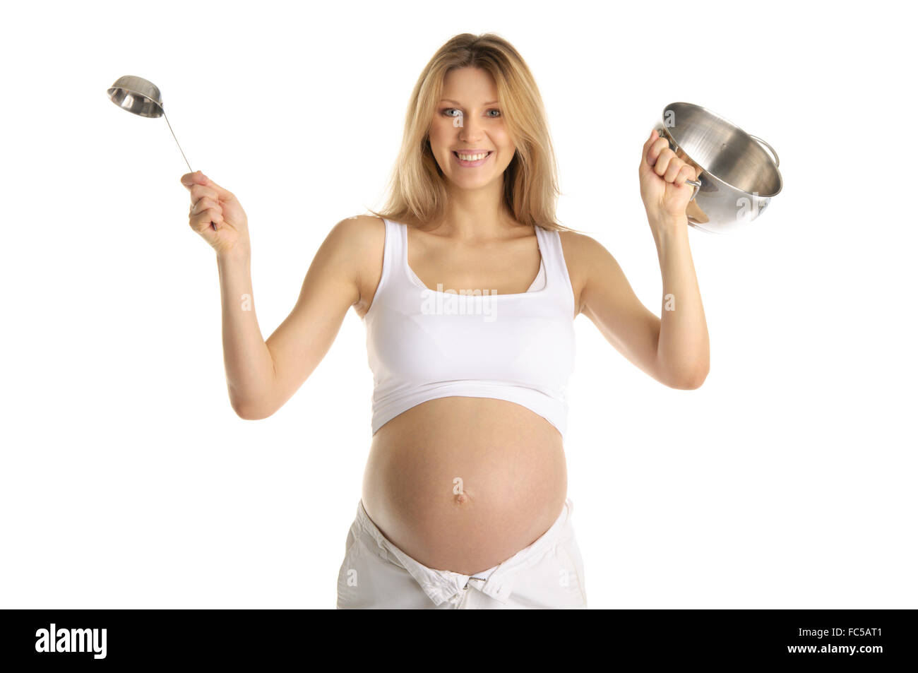 Felice donna incinta con utensili da cucina Foto Stock
