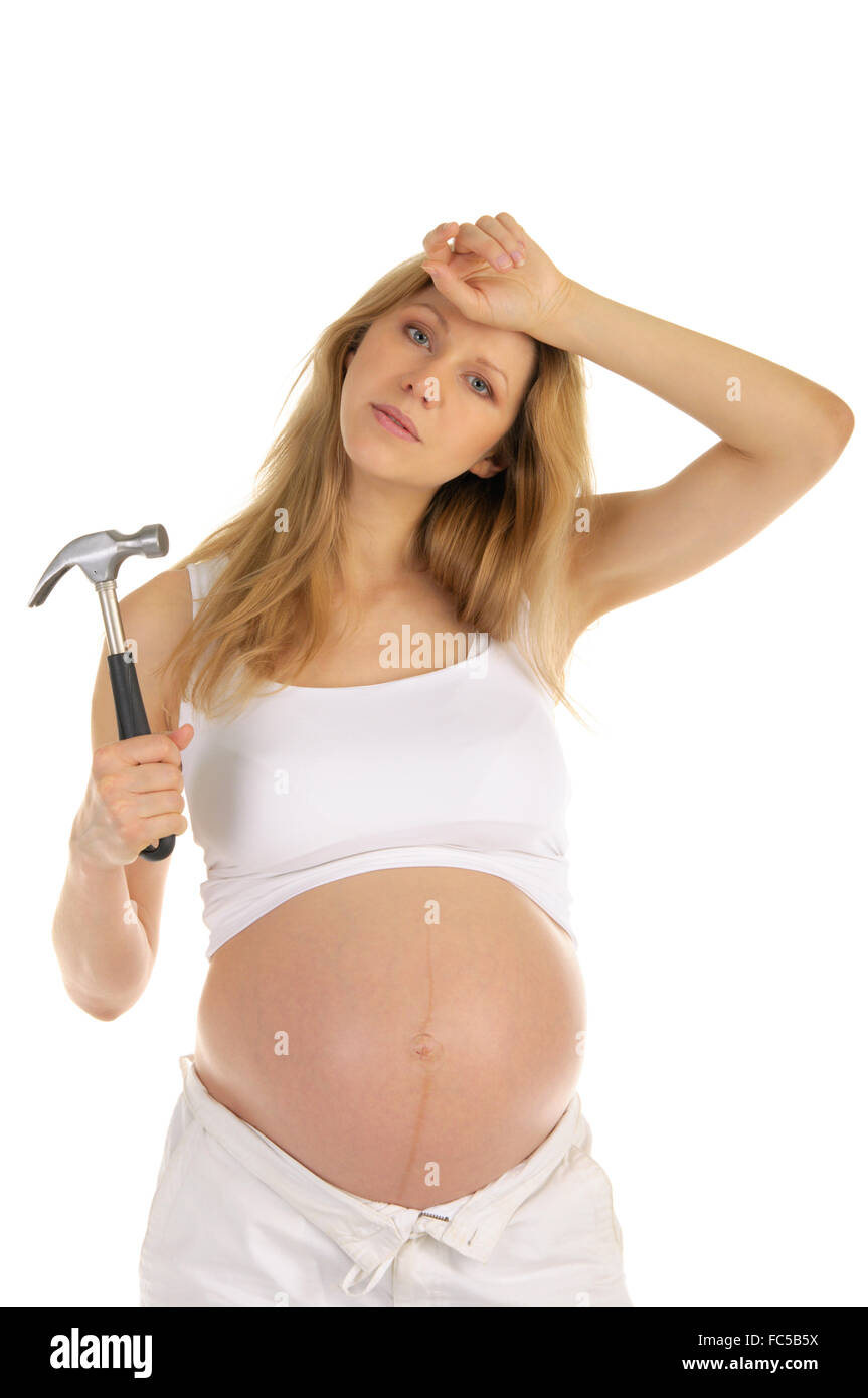 Stanco donna incinta con un martello Foto Stock