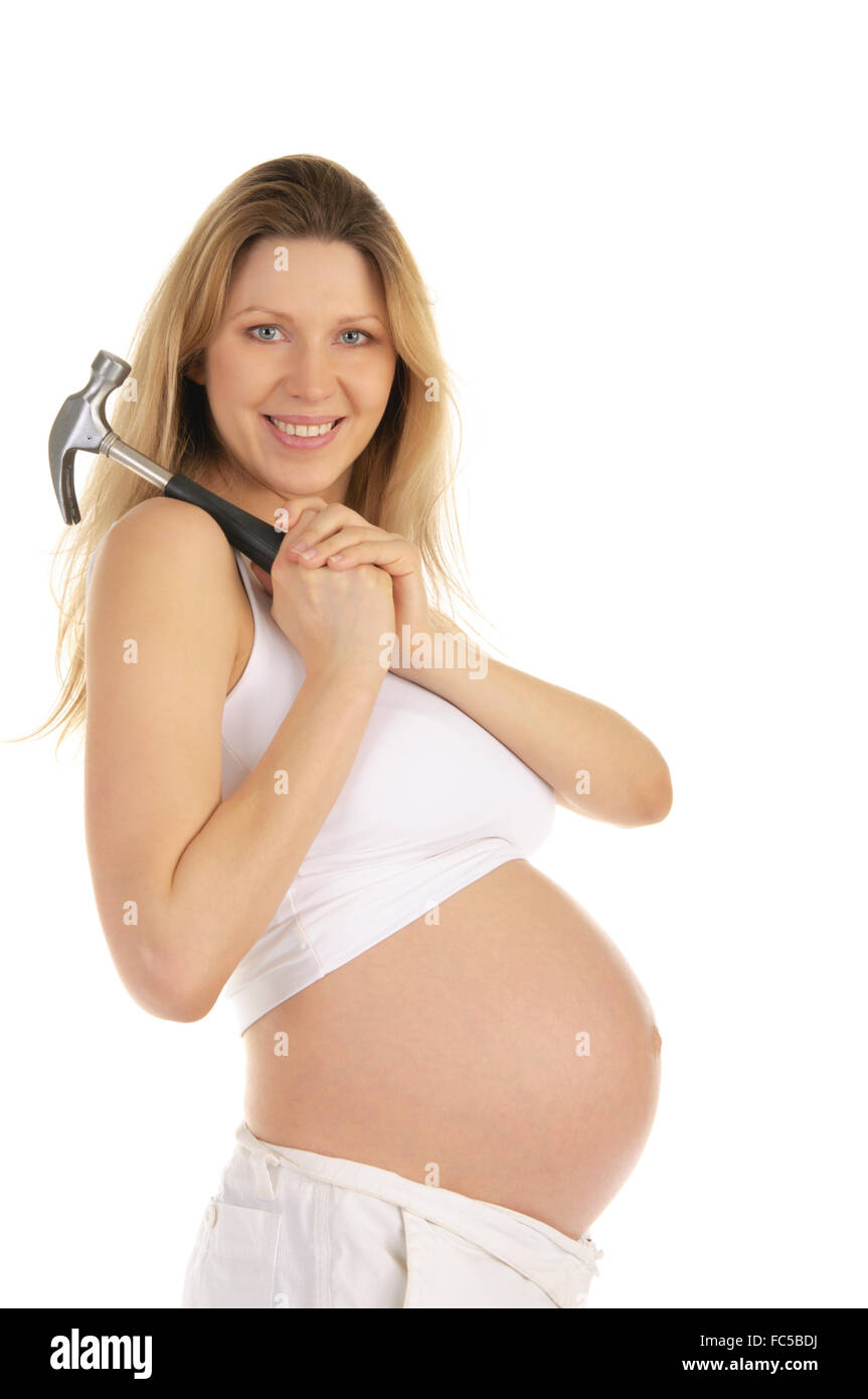 Felice donna incinta con un martello Foto Stock