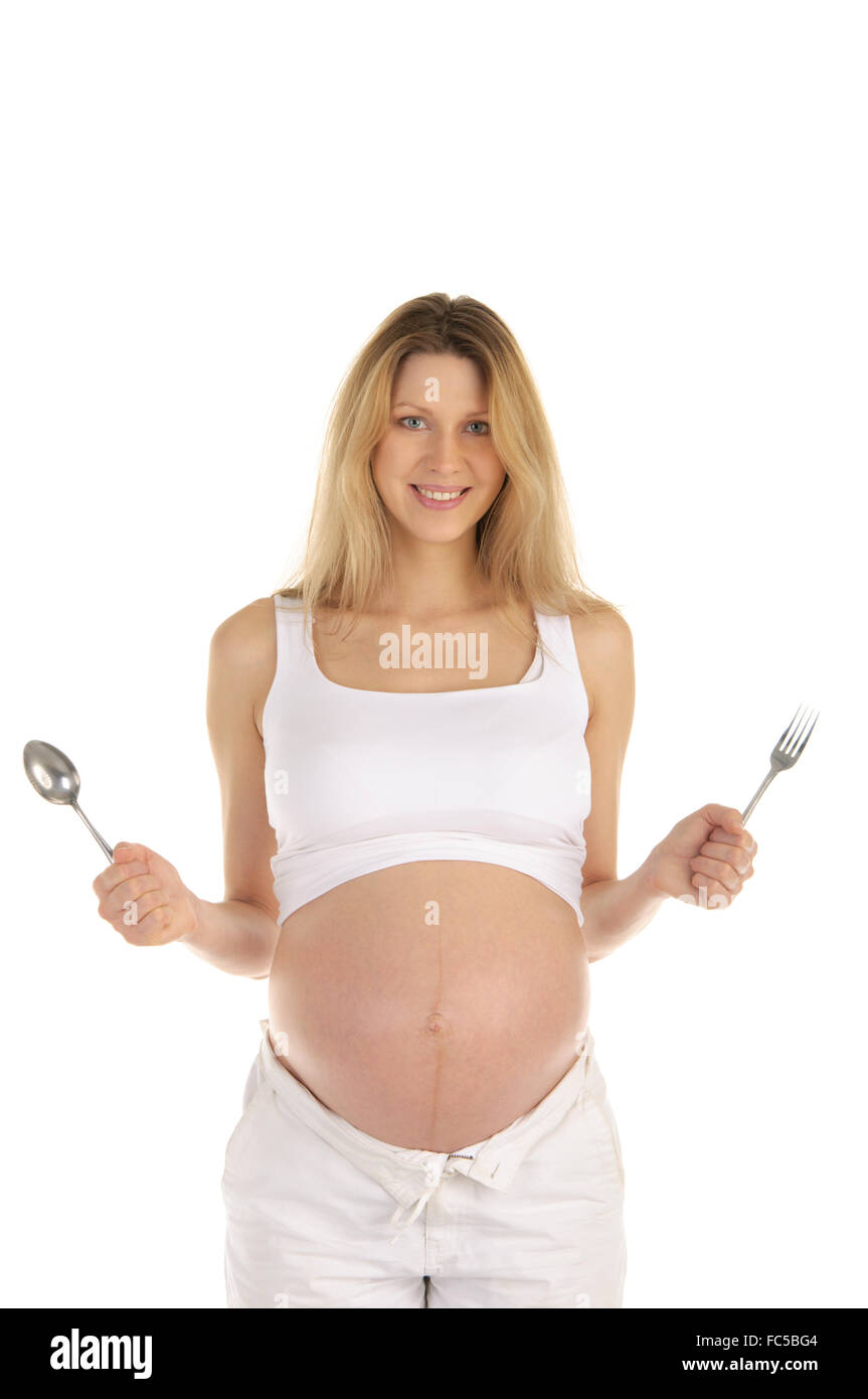 Donna incinta con un cucchiaio e forchetta Foto Stock