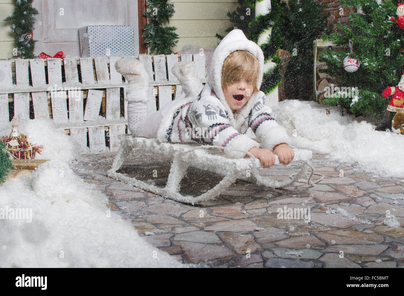 Bambino slittino in cantiere di neve invernale Foto Stock