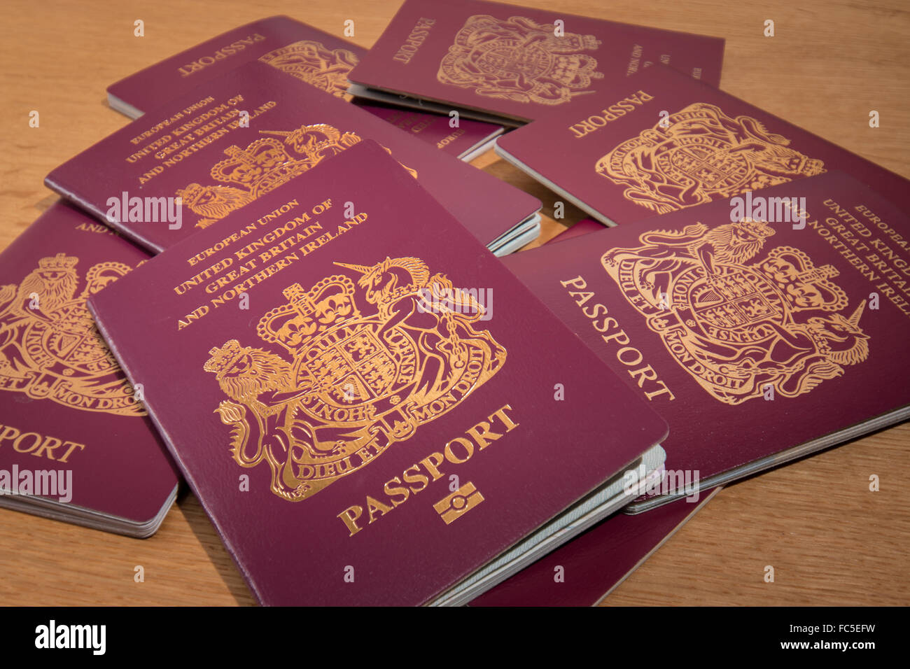 Passaporto britannici impilati su una scrivania in legno. Foto Stock