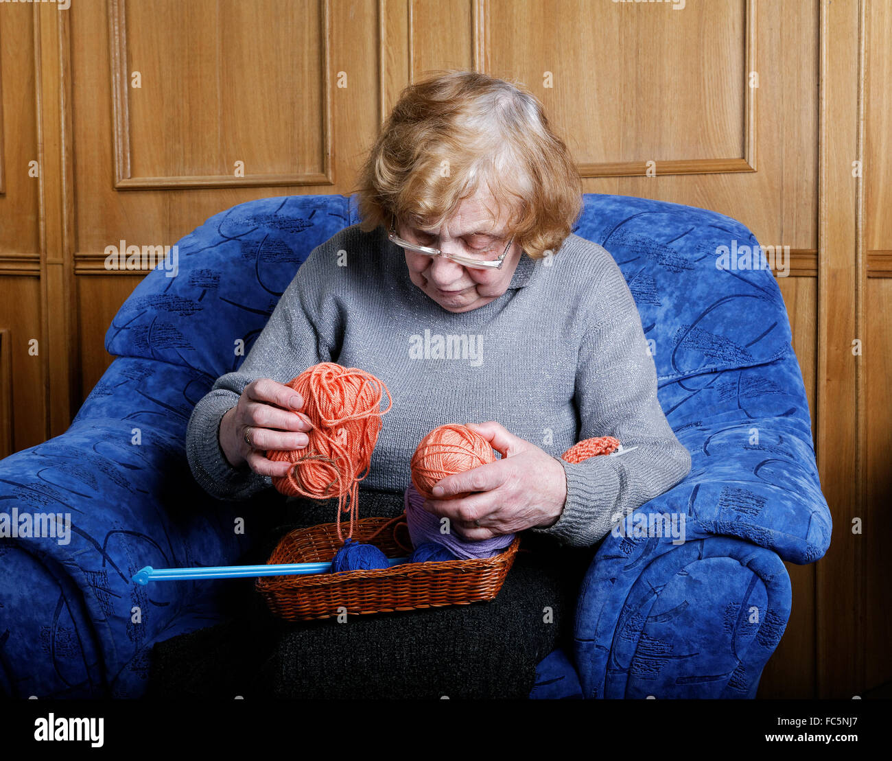 La vecchia donna si siede in una poltrona Foto Stock