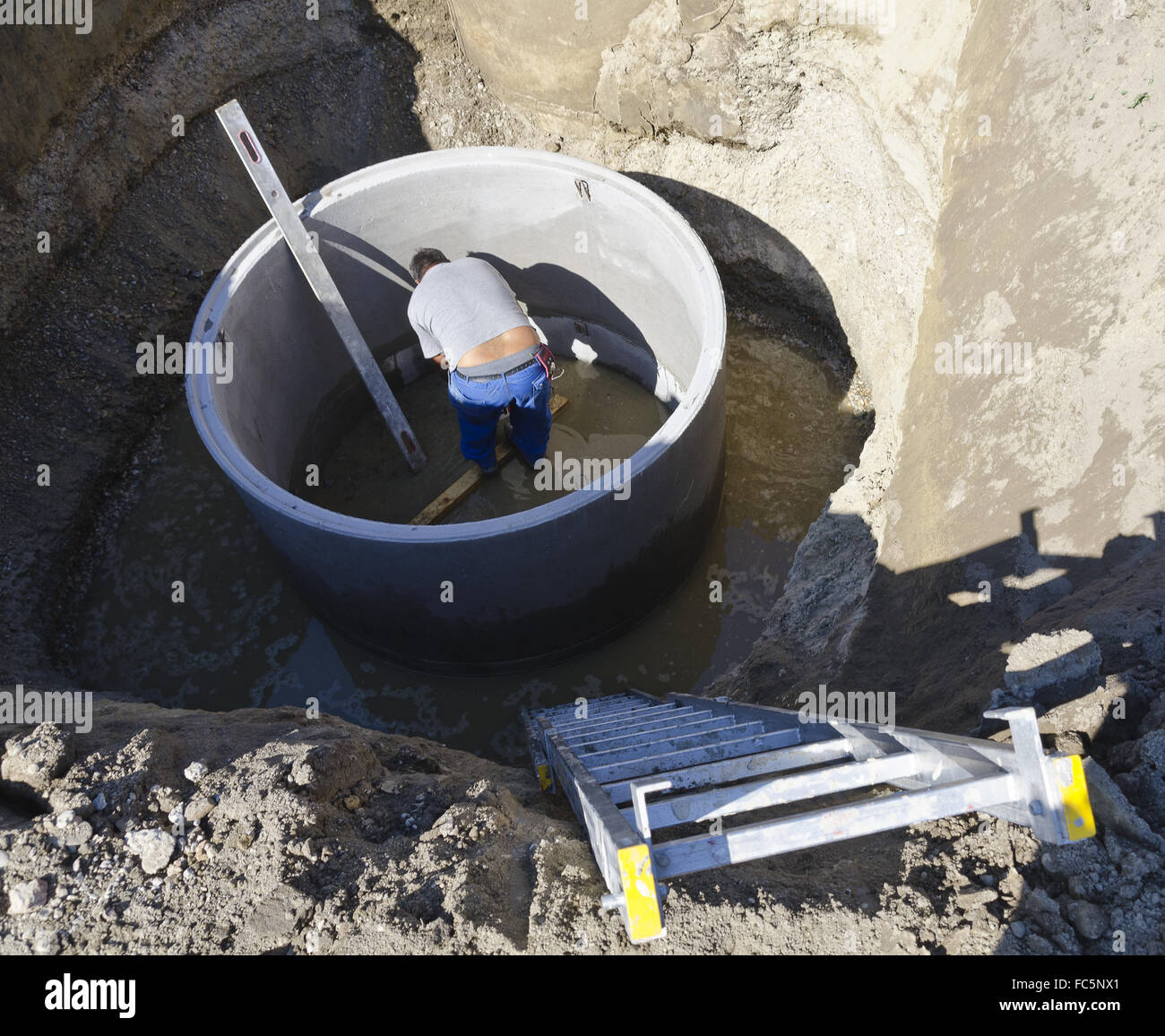 Lavoratore in un albero di calcestruzzo Foto Stock
