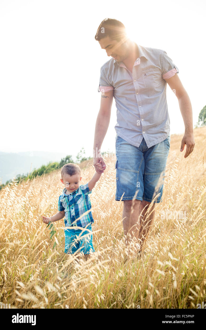 Uomo e ragazzo camminare attraverso il campo Foto Stock