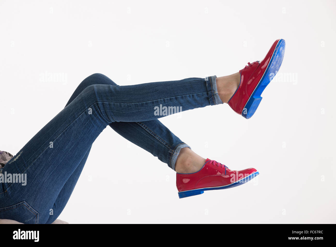 La donna per le gambe in blue jeans e scarpe rosso Foto Stock